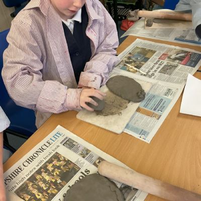 Children making clay lizards